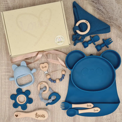 Coffret de naissance en bleu avec un plateau en forme de panda, des jouets et des couverts, tous imprimés du nom Louis.
