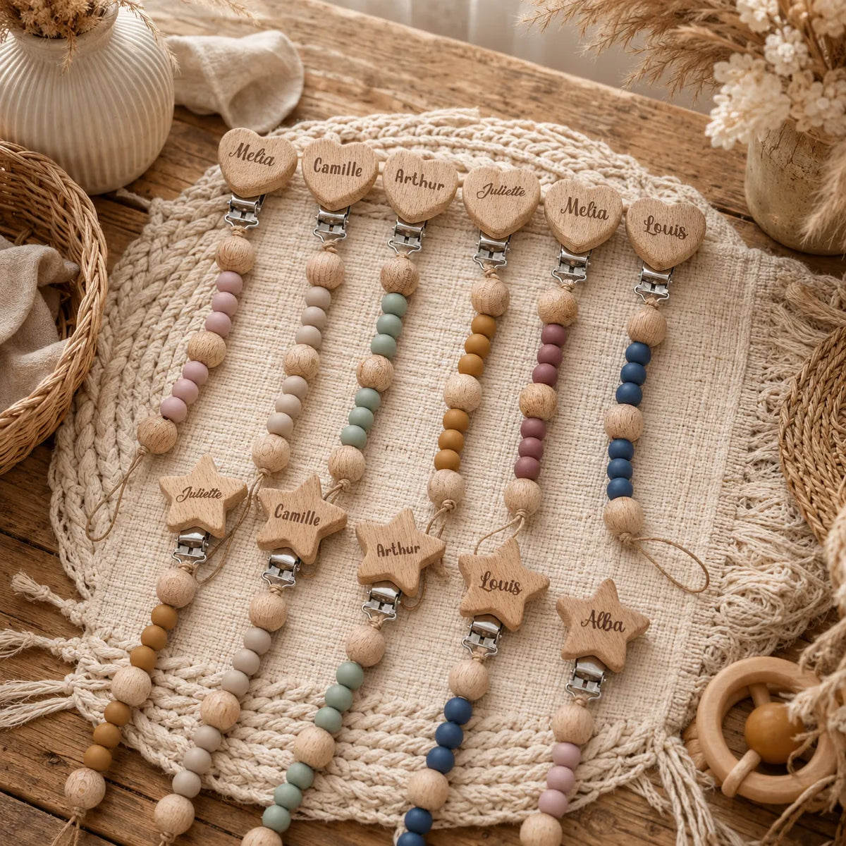 Attaches tétines personnalisées avec prénom en bois et silicone, modèles cœur et étoile pour bébé, présentées sur une table naturelle dans un style doux et artisanal